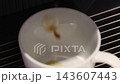 Pouring coffee slow motion footage. Close up white coffee cup. It captures pouring fresh coffee followed by hot water or milk. Create hot Americano Cappuccino or latte coffee. Fresh brew cafe concept 143607443