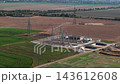 Aerial drone view of electrical substation and high voltage power pylons construction site agricultural fields in Germany. Modern electricity infrastructure distributes energy rural transmission grid 143612608