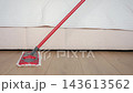 Person cleaning laminate floor with flat mop in bedroom. Mop moving across wooden floor near bed. House cleaning and home hygiene 143613562