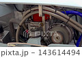 Running vintage car engine with rotating alternator pulley and braided steel hoses close up in detail. 143614494