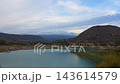 Evening timelapse of Amadorio reservoir in Spain with stormy rain clouds gathering over mountains and turquoise water. 143614579
