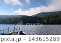 秋晴れの白駒池・青空と山並みを望む桟橋と湖畔のボートの景色 143615289
