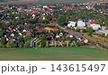 Aerial drone view of Niederndodeleben village in Germany with residential houses gardens green farmland. Scenic autumn landscape shows suburban housing colorful trees and peaceful rural surroundings 143615497