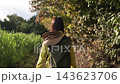 A follow shot of a woman walking in the Shibusawa Hills in autumn. 143623706
