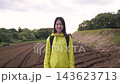 A zoomed-in import rate of a woman smiling against a backdrop of fields in a hilly area. 143623713