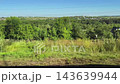 View of green landscape and buildings in the distance on a clear day 143639944