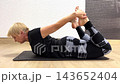 A person performs a backbend pose in a studio setting, demonstrating strength and flexibility through various stages of the position 143652404