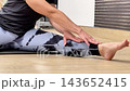 Person performs leg and foot stretching exercises at a fitness center. They focus on different angles to enhance flexibility 143652415