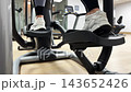 Person uses an elliptical machine for workout at a gym in the morning. Focus on foot movements and gym equipment 143652426