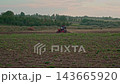 Red Tractor Plowing Agricultural Field at Sunset Wide Shot 143665920