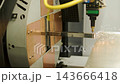 Automated CNC laser cutting machine processing a square metal pipe with bright 143666418