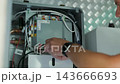 HVAC Technician Adjusting Heat Pump and Boiler System in Modern Mechanical Room 143666693