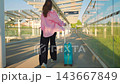 Caucasian woman pulling a suitcase and running, late for flight.  143667849