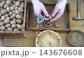Male hands clean nuts with a nut cracker. Close-up. Walnut in shell top view. 143676608