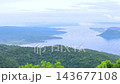 Scenic aerial view of a blue lake surrounded by green hills and mountains 143677108