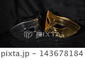 Black and Gold Glitter Masquerade Mask on Dark Background, Mysterious Carnival Atmosphere. 143678184
