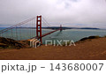 High angle view of the Golden Gate Bridge stretching across the bay under a cloudy sky. 143680007