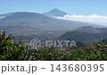 Mount Teide rises hazy above the farmland of La Laguna seen from a high Anaga viewpoint. Two of Tenerife's landmarks framed together for travel guides and tourism campaigns. 143680395