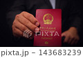 Chinese Passport Held In Hand Close Up 143683239