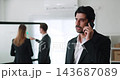 Portrait of thoughtful Middle Eastern businessman talks on mobile phone in office lobby. Organization CEO contacts to partner by smartphone in business center 143687089