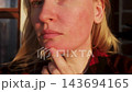 Close up portrait of a woman with erythrophobia, blushing syndrome and idiopathic erythema checking her sensitive skin and facial redness outdoors. Portrait of adult female touching her face with coup 143694165