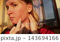 Close up portrait of a woman with erythrophobia, blushing syndrome and idiopathic erythema checking her sensitive skin and facial redness outdoors. Portrait of adult female touching her face with coup 143694166
