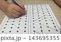 Close up of child hand drawing lines between dots on paper logic puzzle worksheet for home preschool learning back to school study stock footage. 143695355