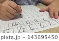 Close up of little child hand tracing zero digits on paper math worksheet during preschool handwriting preparation for school stock footage. 143695450