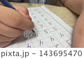 Macro close up of child hand writing numbers in grid notebook with ballpoint pen during elementary math lesson home study stock footage. 143695470
