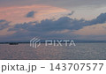 Passenger boat crossing calm lake at dusk under pastel sky with birds and distant mountains on horizon, tranquil evening landscape scene for travel and nature usage 143707577