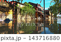 flooded city or town with buildings submerged in overflow water and mud, village underwater after heavy tropical rain and typhoon, consequences with dirt on the street 4k 143716880