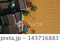 flooded city or town with buildings submerged in overflow water and mud, village underwater after heavy tropical rain and typhoon, consequences with dirt on the street, aerial drone view 4k 143716883