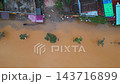 flooded city or town with buildings submerged in overflow water and mud, village underwater after heavy tropical rain and typhoon, consequences with dirt on the street, aerial drone view 4k 143716899