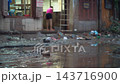 person cleaning house from water and mud after flood, woman with mop recover submerged underwater home after flooding, restoration of building after natural disaster, Hoi An Vietnam 4k 143716900