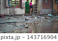 person cleaning house from water and mud after flood, woman with mop recover submerged underwater home after flooding, restoration of building after natural disaster, Hoi An Vietnam 4k 143716904