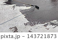 A construction worker applies a bituminous waterproofing layer to an exposed floor surface using a paint roller. This protective coating prevents rainwater leakage into the structure below. 143721873