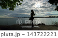 Experience the beautiful Silhouette Yoga practice by the Water during the tranquil Sunset 143722221