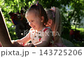 Hands of daddy pushes two little daughters on big toy motorcycle in summer garden. Happy small sisters riding plastic balance bike with dad on sunny day. Loving family enjoy active weekend at nature 143725206