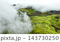 Aerial view of clouds sweeping across mossy volcanic highlands, revealing emerald plateaus, Iceland 143730250