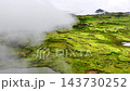 Aerial view of clouds sweeping across mossy volcanic highlands, revealing emerald plateaus, Iceland 143730252