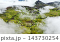 Aerial view of clouds sweeping across mossy volcanic highlands, revealing emerald plateaus, Iceland 143730254