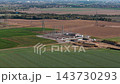 Aerial drone view of electrical substation and high voltage power pylons construction site agricultural fields in Germany. Modern electricity infrastructure distributes energy rural transmission grid 143730293