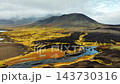Black volcanic mountain with golden moss ribbon under cloudy sky from aerial viewpoint, dramatic highland landscape scene for nature and travel visuals 143730316