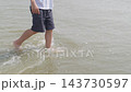 Close-up of a boys legs splashing through shallow sea water an unrecognizable child 143730597