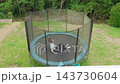 A teenage girl is jumping on a trampoline flip jump backyard outdoors 143730604