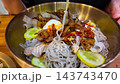 Korean cold noodles, naengmyeon. Sliced cucumber, pickled radish. savory food 143743470