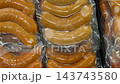 Close up of vacuum sealed orange food portions arranged in rows, showing glossy plastic packaging, texture, seams, and prepared food storage suitable for packaging, retail, culinary, and food video Close up of vacuum sealed orange food portions arranged in rows, showing glossy plastic packaging, texture, seams, and prepared food storage suitable for packaging, retail, culinary, and food video 143743580