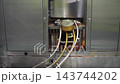 Industrial canning machine sealing mussels tins in a cannery 143744202