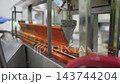 Automated cannery production line filling mussels cans with sauce 143744204