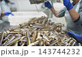 Female workers processing razor clams in a seafood cannery 143744232